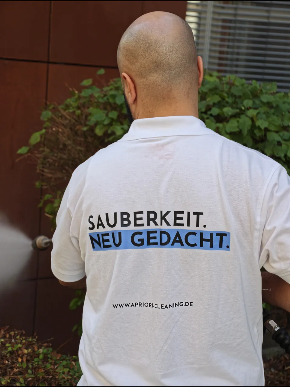 Apriori-Mitarbeiter im Einsatz, auf dem Rücken der Leitsatz „Sauberkeit. Neu gedacht.“