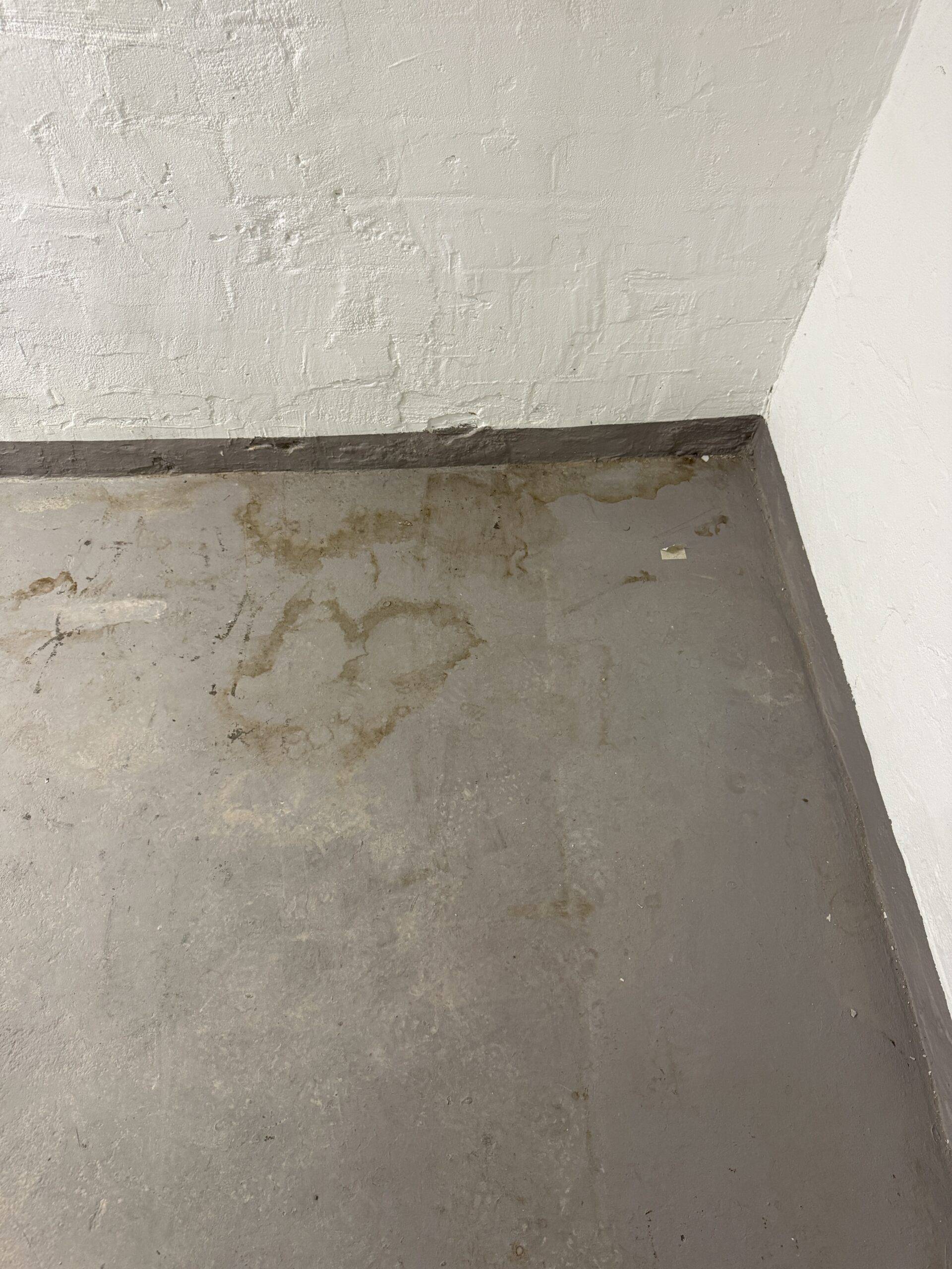 Boden vor der Grundreinigung — Wasserflecken und Schmutzaufbau auf Betonoberfläche